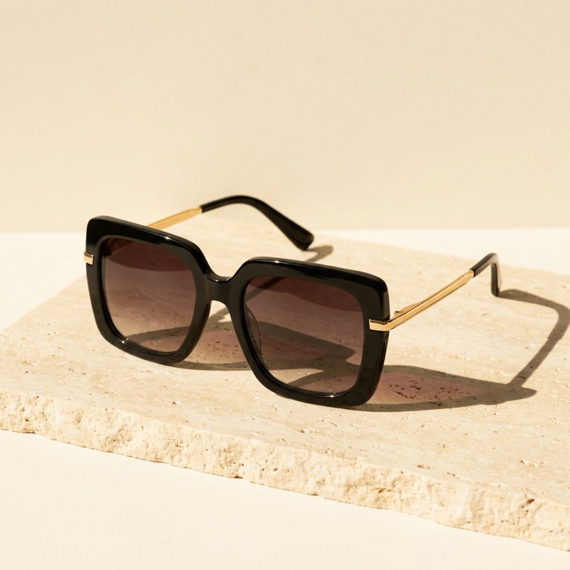 Oversized black square sunglasses with brown gradient lenses.